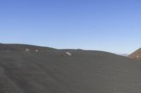 people flying kites on the top of a mountain in the desert land of a large rocky area