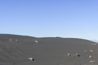 people flying kites on the top of a mountain in the desert land of a large rocky area