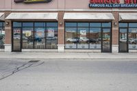 there is a pizza parlor front with a sign in the street for pizza hut store