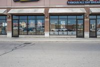 there is a pizza parlor front with a sign in the street for pizza hut store