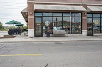 there is a pizza parlor front with a sign in the street for pizza hut store