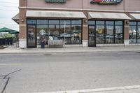 there is a pizza parlor front with a sign in the street for pizza hut store