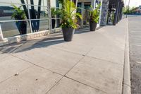 planters line the sidewalk in front of a business building that houses an entertainment center