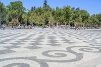 a walkway has black and white patterns on it in a park with trees in the background