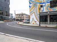 the corner of the city street has been painted in a bold swirly color scheme