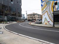 the corner of the city street has been painted in a bold swirly color scheme