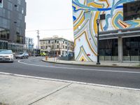 the cars are driving along a busy street with many buildings in front of them to show art work