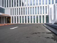 the front door of an office building with a sign and arrow mark on it's concrete