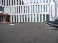 the front door of an office building with a sign and arrow mark on it's concrete