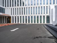 the front door of an office building with a sign and arrow mark on it's concrete