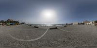 a 360 - ball view of a beach and buildings in the background with an empty bench