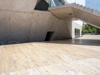 an empty wooden floor next to the entrance of a building with a big triangular roof
