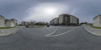 an upside down view of a deserted road in front of some tall buildings with cars parked along the side