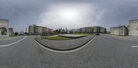 the view of buildings from a 360 - fisheye lens on a parking lot with a paved driveway