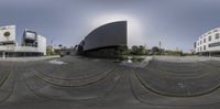 a 360 camera image shows some architecture as a building sits behind it in front of it