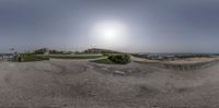 a panorama photograph taken on an internet device shows the view from the sidewalk of a beachside