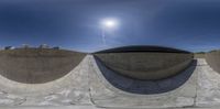 three circular bowls sit in the middle of the concrete floor of a skate park and some buildings