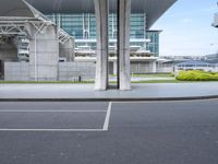 two men walking across a runway at an airport terminal that has a control tower and parking lot