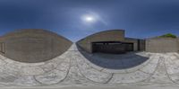 a panoramic looking image of a skateboarder riding on a rail over cement ramps
