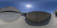 the view of a skateboard ramp in a concrete building under a clear blue sky