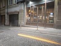 a store front that is on the street next to a curb by a pole and lamp