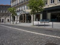 there is a building with several shops and people walking by it along the street in front of them