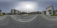 a fish eye lens with cars parked at the bottom of a road and buildings on the other side