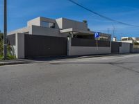 a street that has a fence around it in front of a building with a parking sign