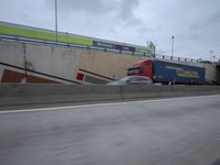 the view of the front entrance to a kmk store from a freeway window, with a building on one side