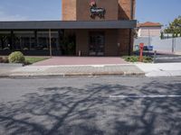 a restaurant sits empty, on a street corner in the middle of town in summer