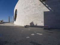 a white building with a shadow of two people sitting down on the ground near the window