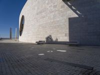 a white building with a shadow of two people sitting down on the ground near the window