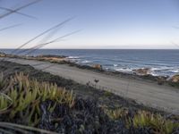 the dirt road is empty on the ocean beach side road that takes up to the rocky shore