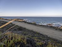 the dirt road is empty on the ocean beach side road that takes up to the rocky shore