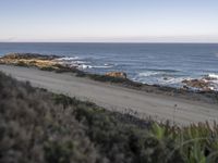 the dirt road is empty on the ocean beach side road that takes up to the rocky shore