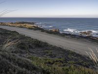 the dirt road is empty on the ocean beach side road that takes up to the rocky shore