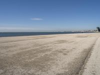 a person sitting on the beach in front of the ocean, looking at the water