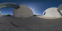 three spherical pictures of a cement structure at the base of an arch with a blue sky in the background