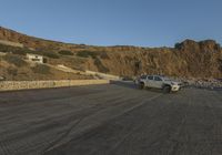 a truck is parked along the street beside some cliffs and cliffs that are very steep and rocky