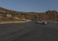 a truck is parked along the street beside some cliffs and cliffs that are very steep and rocky