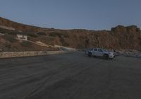 a truck is parked along the street beside some cliffs and cliffs that are very steep and rocky