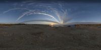 the sun is shining behind the water and some clouds over some desert land in a circular pattern