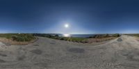 this 360 - shot has a blue sky and clear water in the background, as seen from a fish eye perspective