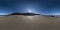 a large rock on top of a sandy beach on a clear day - shot using fisheye lens