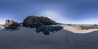 an image of some very big rock formations in the sand at the beachside of a small ocean