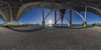 there is a fish eye view of some sort of structure in this picture that's in the sand