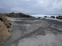 a concrete walkway that leads down to the ocean and has waves crashing on it,