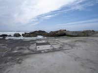a concrete walkway that leads down to the ocean and has waves crashing on it,