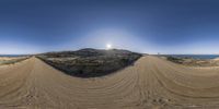 a view of the sun from behind some sand dunes while riding a skate board on dirt track