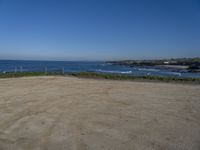 the empty parking lot in front of the beach is a bit empty with a small blue sky and blue water on a sunny day